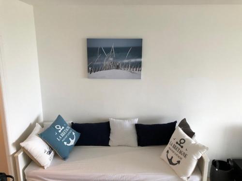 een woonkamer met een bank met kussens erop bij Résidence des 3 iles in Quiberon