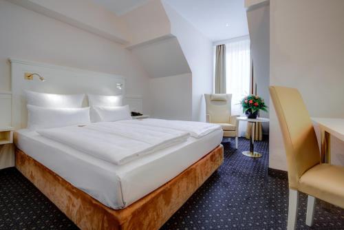a hotel room with a large bed and a desk at Hotel Fürst Bismarck in Hamburg