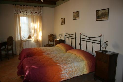 Schlafzimmer mit einem Bett, einem Schreibtisch und einem Fenster in der Unterkunft Agriturismo Cascina Nuova in Barge