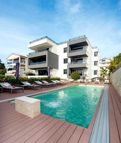 a building with a swimming pool in front of a building at Villa Marija in Sveti Filip i Jakov
