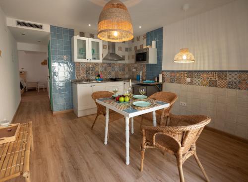 a kitchen with a table and chairs in a room at Casas del Castillo Peñíscola-Intramuros Suites in Peñíscola