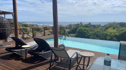 a deck with chairs and a swimming pool at Chilled Vibes in Ponta Mamoli