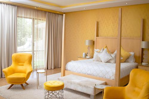 a bedroom with a bed and a yellow chair at Masawara Urban Retreat in Harare