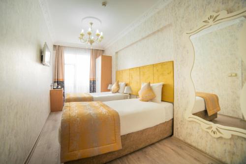 a hotel room with two beds and a chandelier at Istanbul Old City Sultanahmed Miran Hotel in Istanbul