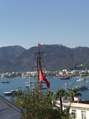 a tall ship with a red flag in a harbor at Castello Marmaris Holiday Home in Marmaris