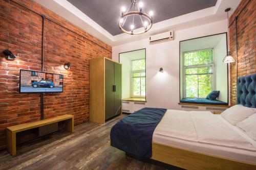 een slaapkamer met een bed en een bakstenen muur bij Loft Design Apartments on Desyatynnyi Ln, 7 in Kiev