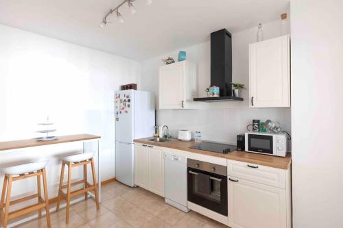 a kitchen with white cabinets and a white refrigerator at Atlantic Flat - Acogedor piso en Vegueta, Las Palmas in Las Palmas de Gran Canaria