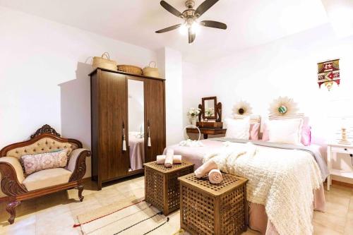 a bedroom with a bed and a chair and a fan at Atlantic Flat - Acogedor piso en Vegueta, Las Palmas in Las Palmas de Gran Canaria