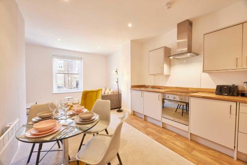 a kitchen and dining room with a table and chairs at Wearmouth boutique apartment in Sunderland