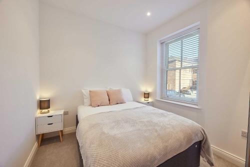 Habitación blanca con cama y ventana en Wearmouth boutique apartment, en Sunderland