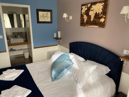 a bed with a blue headboard in a room at Le Domaine du Gravier in Gramat