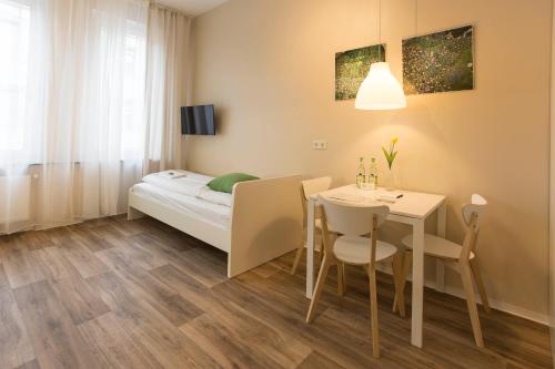 a small room with a table and a bed at GuestHouse Köhn51, zentral gelegene, stilvoll eingerichtete Zimmer mit eigener Teeküche in Nürnberg