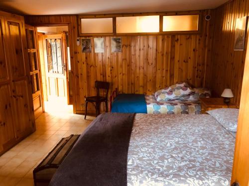 sypialnia z łóżkiem w pokoju z drewnianymi ścianami w obiekcie CASA VACANZE NORA w mieście Chamois