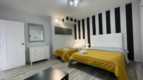 een kleine slaapkamer met 2 bedden en een tafel bij penthouse benal beach in Benalmádena