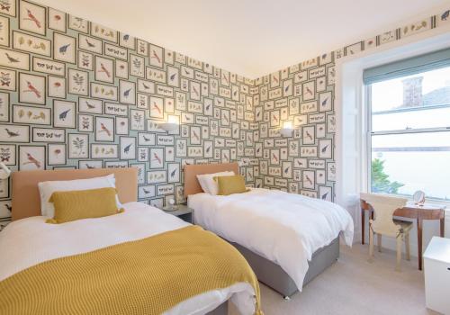 1 dormitorio con 2 camas y pared de papel pintado en East Cliff, en North Berwick