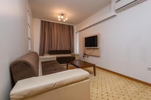 a living room with a couch and a television at VIP Apartments in Sarajevo