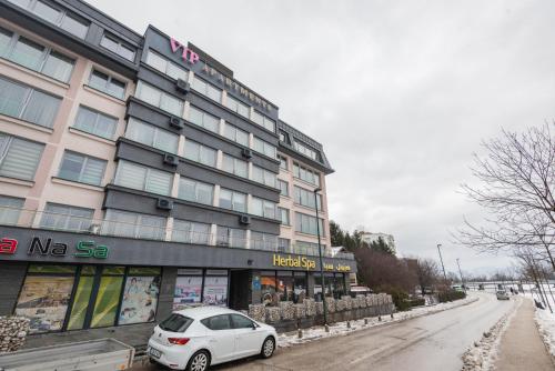 a white car parked in front of a building at VIP Apartments in Sarajevo
