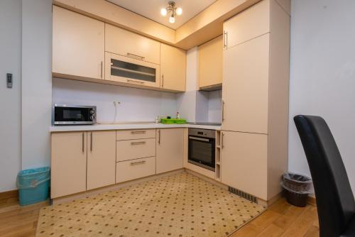 a small kitchen with white cabinets and appliances at VIP Apartments in Sarajevo