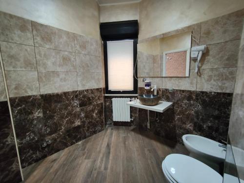a bathroom with two toilets and a sink and a window at B&B MaisonAlysie in Foggia