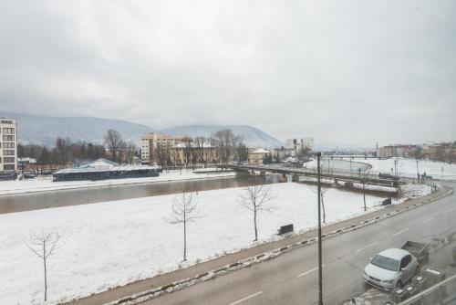 a snowy road with a car parked on it at VIP Apartments in Sarajevo
