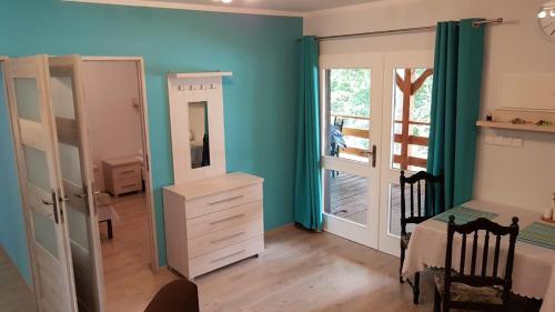a bedroom with blue walls and a table and a mirror at Urocza Przystan in Kiemiany
