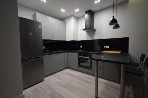 een keuken met zwarte apparatuur en een zwart aanrecht bij Londyńska 9 in Gorzów Wielkopolski