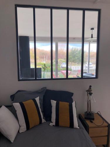 - une chambre avec un lit et trois fenêtres dans l'établissement Résidence goulvars., à Quiberon