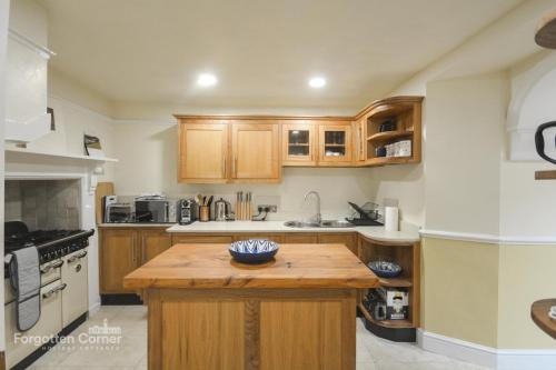 a kitchen with wooden cabinets and a wooden island at Kelvin House - Cawsand in Cawsand