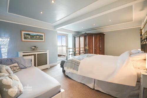 a bedroom with two beds and a fireplace at Kelvin House - Cawsand in Cawsand