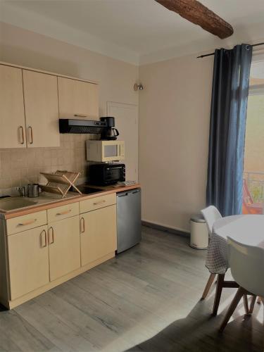 une cuisine avec un comptoir et une table avec des chaises dans l'établissement Les 12 Sables, au Lavandou