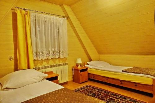 ビャウカにあるPokoje Gościnne u Moniの小さなベッドルーム(ベッド2台、窓付)