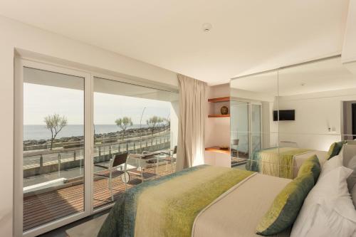 ポンタ・デルガダにあるOcean Views by Azores Villasのベッド2台とバルコニーが備わるホテルルームです。