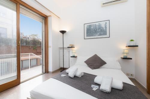 a bedroom with a white bed and a large window at Parioli Garden-Rental in Rome in Rome