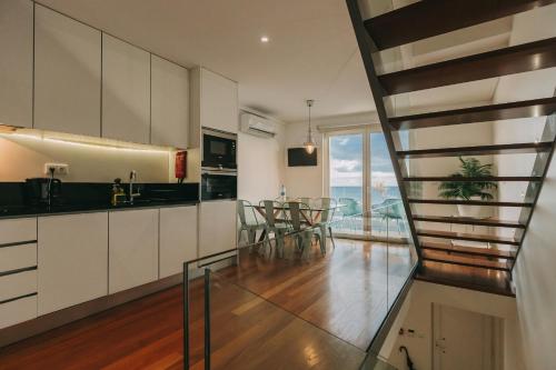 a kitchen with white cabinets and a glass floor at Ocean View by Azores Villas in Ponta Delgada