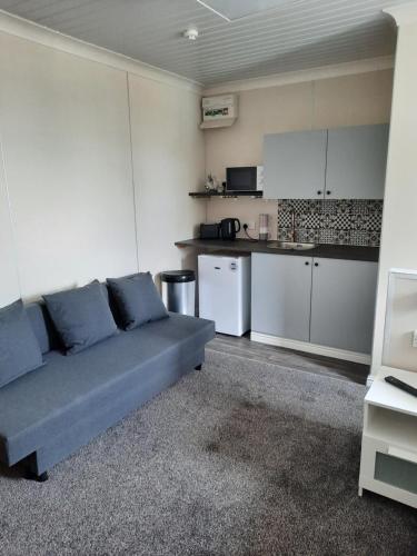 a living room with a couch and a kitchen at The Townhouse Self Catering in Dumfries