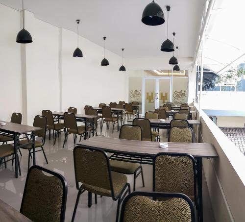 une salle à manger avec des tables, des chaises et des lumières dans l'établissement HOTEL LENGKONG 2, à Bandung
