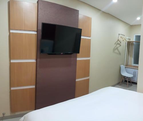 um quarto com uma cama e uma televisão de ecrã plano em HOTEL LENGKONG 2 em Bandung