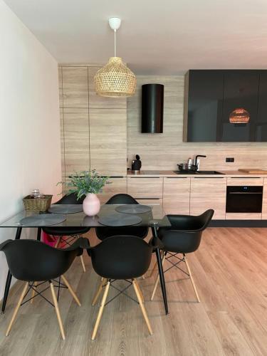 a dining room with a black table and chairs at Sunny Pobierowo Euronia Apartament in Pobierowo