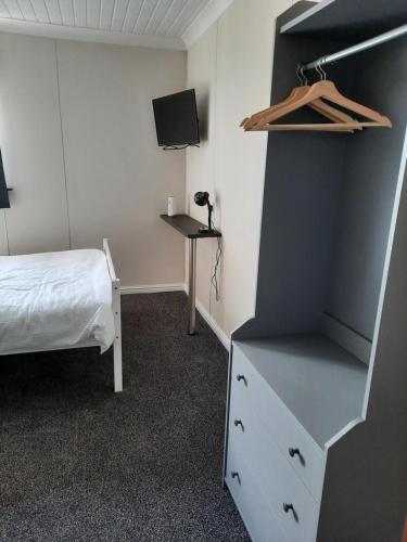 a bedroom with a bed and a dresser and a tv at The Townhouse Self Catering in Dumfries