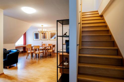 a staircase in a living room with a dining room at Apparthotel Bad Schandau by STEIGER Hotels in Bad Schandau