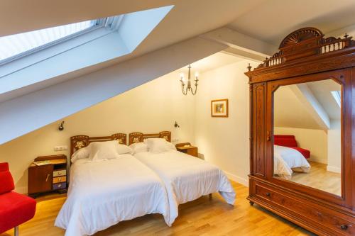 1 dormitorio con 1 cama grande y espejo en Hotel Casa da Galbana, en Friol
