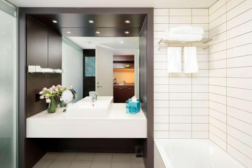 a bathroom with a sink and a mirror at Rydges Wellington in Wellington