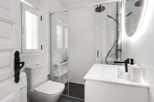 een witte badkamer met een toilet en een douche bij 1 bedroom in Verano Azul, Free Wi-fi in Nerja