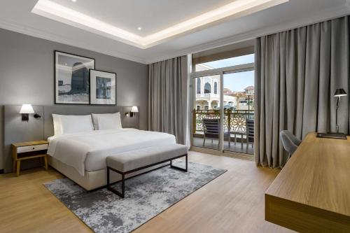 a hotel room with a bed and a balcony at Radisson Hotel Riyadh Airport in Riyadh