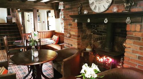 a restaurant with tables and a brick wall with a clock at Slaters Country Inn in Whitmore