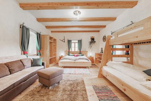 a living room with a bed and a couch at Ferienhaus Spitzenhof - Urlaub am Bauernhof in Mooslandl