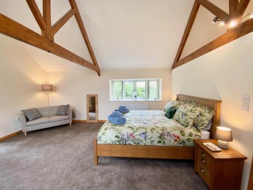 a large bedroom with a bed and a window at Bamford Barn in Ottery Saint Mary