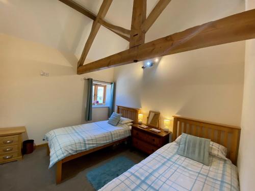 1 dormitorio con 2 camas, vestidor y ventana en The Teddy House, en Ottery St Mary