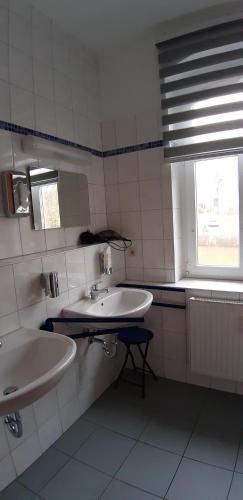 a bathroom with two sinks and a window at Gasthof zum alten Schulmeister in Harra