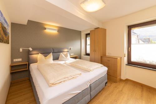 a bedroom with a large bed and a window at Hotel-Restaurant Ehses in Zeltingen-Rachtig